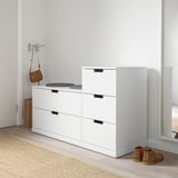 White NORDLI chest with 4 drawers, black handles, in hallway.