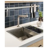 Stainless sink, dark tiles, magnetic knives.