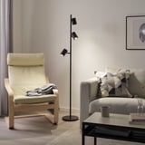 Modern living room with black floor lamp, rocking chair, sofa, and coffee table.