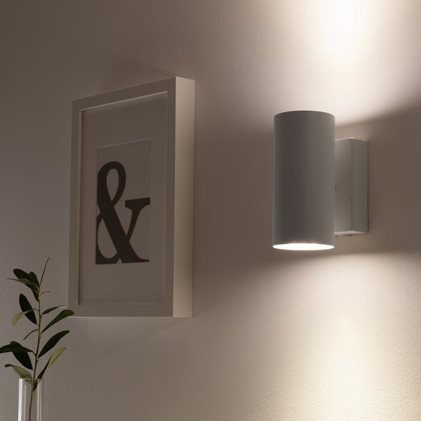 Wall-mounted light fixture with downward glow and upward light reflection.