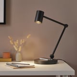 NYMÅNE lamp on white desk with books, flowers, & orange box.