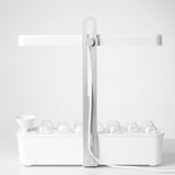 White indoor grow light setup with timer, trays, and clear domes for plant cultivation. Modern, minimalist design for countertop use.