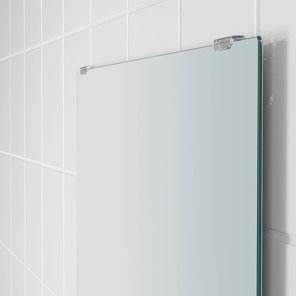 Modern, frameless mirror with sleek, fixed glass shelf. Clean, minimalist design. Slim, chrome fixtures hold it securely.