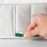 Hand extends mattress part with hook. Durable, adjustable sleep solution for growing children.