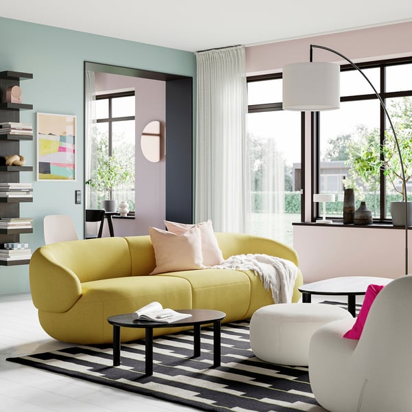 Modern living room with yellow sofa, black/white rug, small side table, large window, and floor lamp.