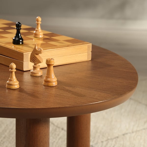 Chess pieces on polished wooden table, showcasing fine grain and craftsmanship.