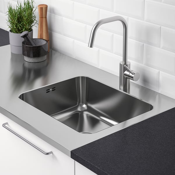 Stainless steel sink and countertop setup, ideal for kitchen or laundry room, includes drain and lid, with sleek faucet and modern design.