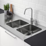 Stainless steel double kitchen sink with modern faucet.