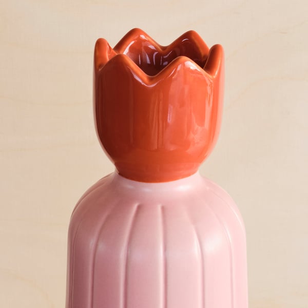 Unique, colorful glazed candle holder with ribbed design and petaled top. Brightens any setting with stylish elegance.