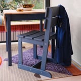 Rustic pine chair, sled legs, high back, near wooden table with coat.