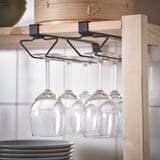 Wooden shelf with hanging wine glass holder, three empty wine glasses suspended.