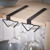 Black metal wine rack on shelf.