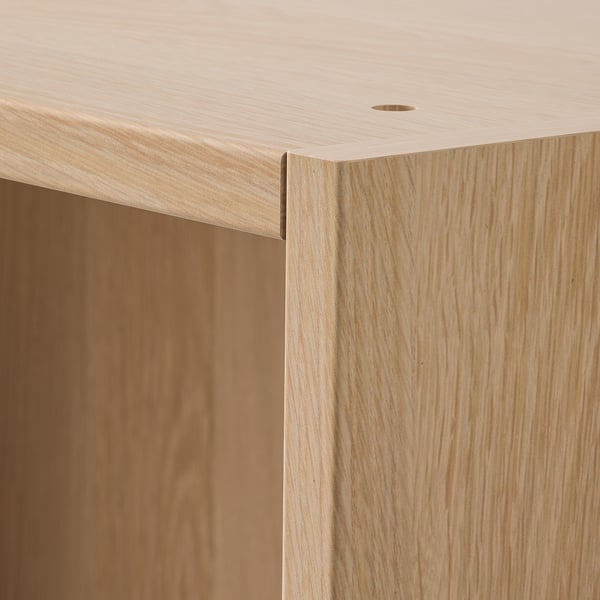 Close-up of wooden wardrobe corner, showing smooth, light wood grain and precise fit.