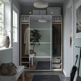 A modern, organized closet with sliding doors, hanging clothes, shelves, baskets, and soft lighting in a minimalist design.