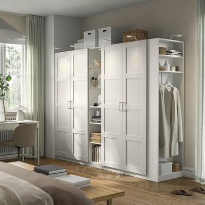 White PAX wardrobe with shelves, compartments, and hanging section.