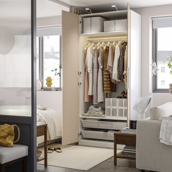 Modern open closet displaying clothes, with storage shelves and accessories.
