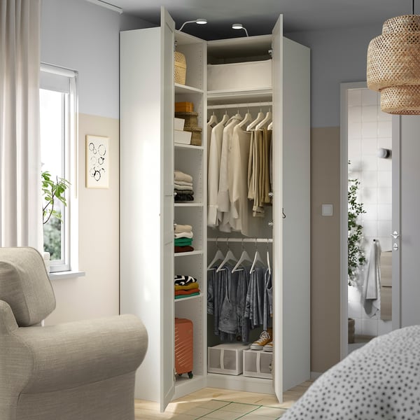 Open wardrobe showing clothes hangers and shelves in a bedroom, demonstrating efficient storage solutions.