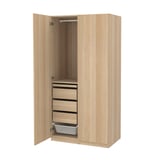 A light wood-colored standing wardrobe named PAX, featuring multiple drawers, a hanging rod, and a mesh basket.