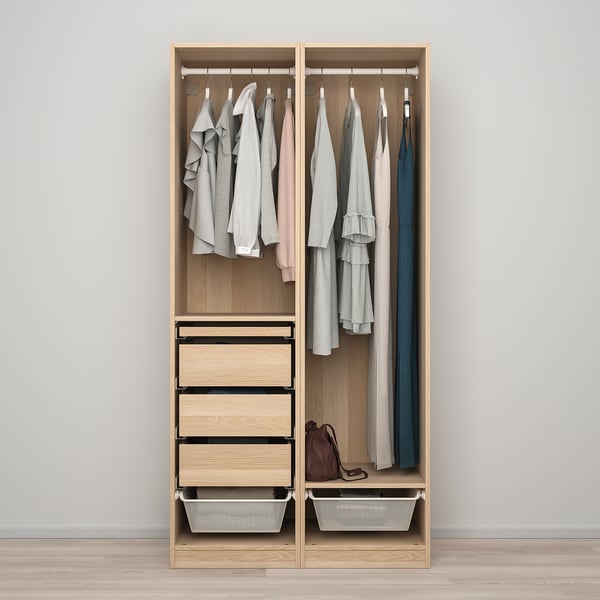 An open wooden PAX wardrobe with drawers and clothes hangers.