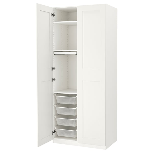 A white ikea PAX wardrobe with open doors, revealing shelves and mesh drawers.