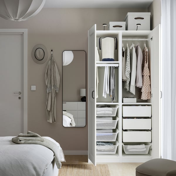 Modern bedroom with open wardrobe displaying organized clothes, shelves, and drawers.