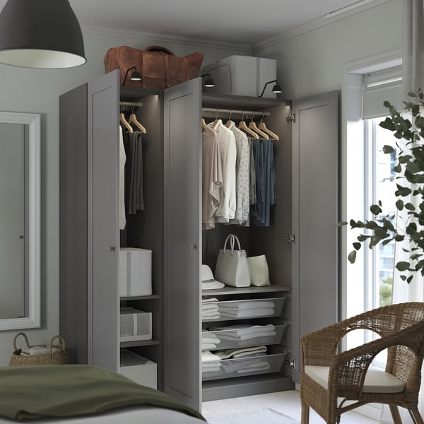 Modern gray wardrobe with clothes, baskets, and storage solutions. Top shelf holds bags, bottom shelves have folded items.