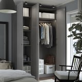 Open wardrobe with clothes, folded towels, and storage boxes in a modern bedroom.