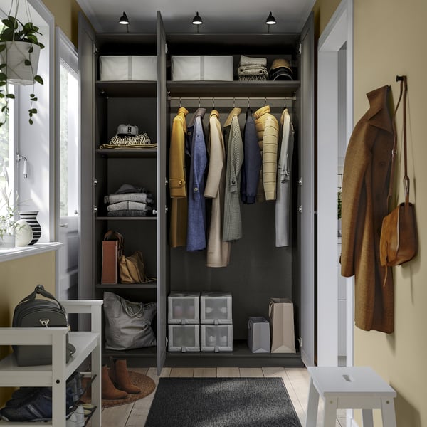 Open wardrobe with clothes hangers, shelves, and storage bins. Coat hooks on right wall.