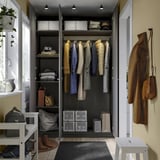 Open wardrobe with clothes hangers, shelves, and storage bins. Coat hooks on right wall.