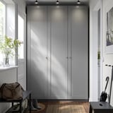 Modern entryway with large gray PAX closet, black shoe rack, brown bag, plant, and umbrella stand.