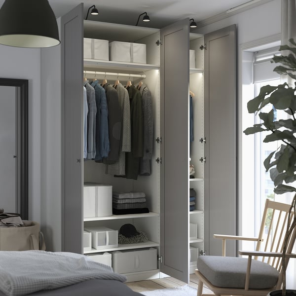 Bedroom wardrobe displaying clothes and storage boxes, highlighting organized interior with shelves and hanging rail.