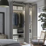 Bedroom wardrobe displaying clothes and storage boxes, highlighting organized interior with shelves and hanging rail.