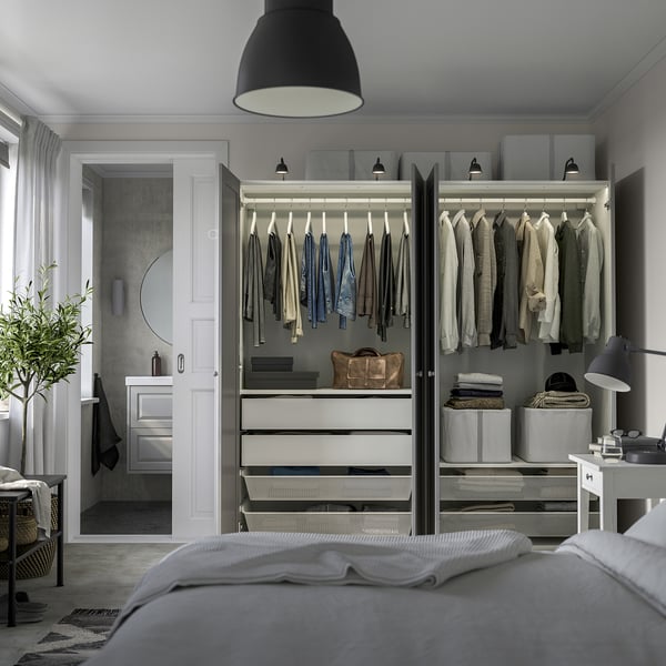 Closed wardrobe with clothes, drawers, bags, andled lights on top.