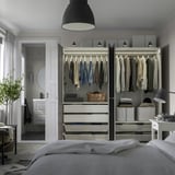 Closed wardrobe with clothes, drawers, bags, andled lights on top.