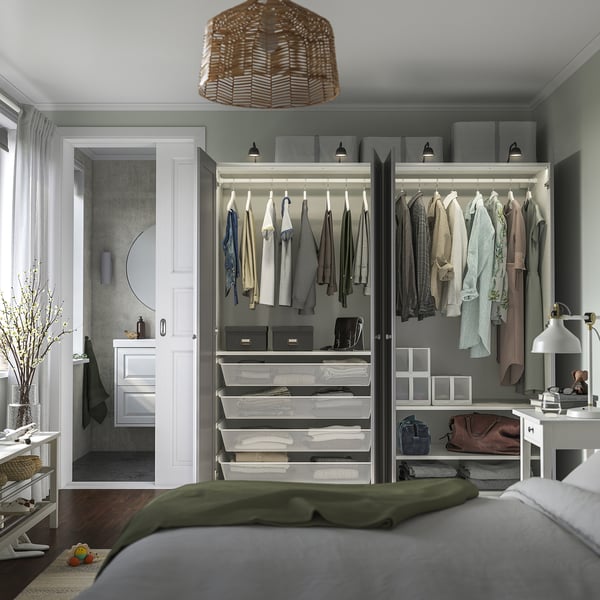 Tidy bedroom with large PAX wardrobe and bedside table, well-lit.