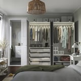 Tidy bedroom with large PAX wardrobe and bedside table, well-lit.