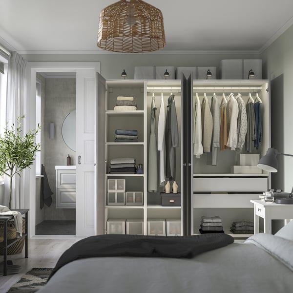 Bedroom with open wardrobe showing clothes and shelves, small bathroom with sink visible through door.