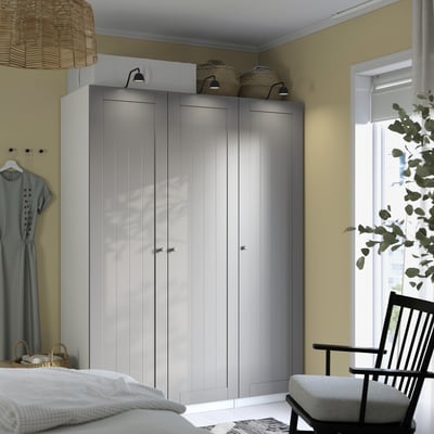 Bedroom with tall gray PAX wardrobe, blue dress, cozy chair.