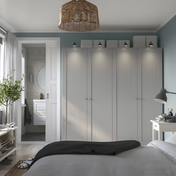 Bedroom with large PAX wardrobe, soft-close hinges, pendant light, and bathroom view with bathtub and mirror. Large bed with folded blankets.