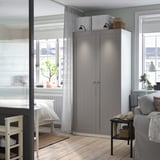 Modern gray wardrobe, tall, minimalist, by window, with couch.