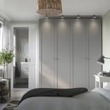Gray PAX wardrobe, warm pendant, small bathroom, natural light, minimalist style.