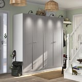 Large grey PAX wardrobe with white doors stands tall between entryway and staircase, housing backpack by its side.