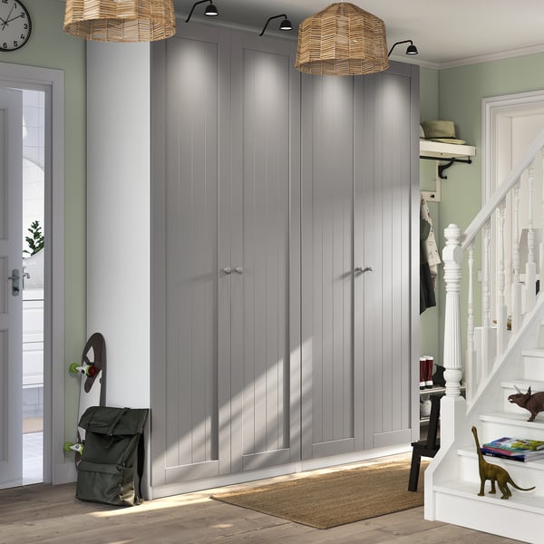 Modern entryway with PAX closets in grey; spacious and sleek. Woven pendants, stair railing, and colorful decor.