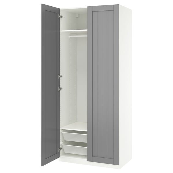 An open ikea PAX wardrobe in white with a grey door, featuring shelves and a mesh basket inside.