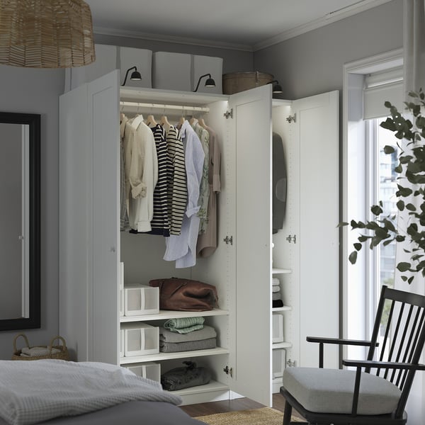 Open wardrobe displaying shirts and folded clothes beneath, showcasing organized storage space.