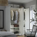 Open wardrobe displaying shirts and folded clothes beneath, showcasing organized storage space.