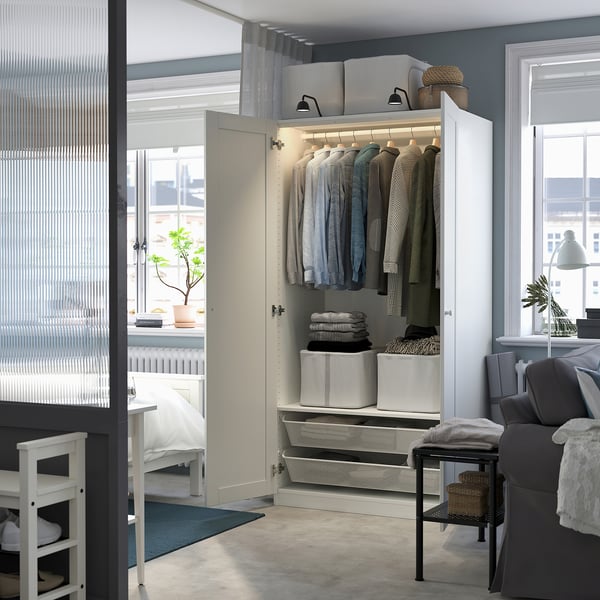 Open wardrobe with clothes, shelves, lighting.