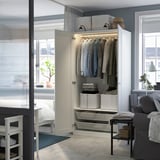 Open wardrobe with clothes, shelves, lighting.