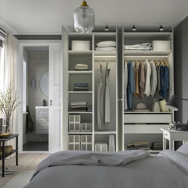 Bedroom with modern wardrobe featuring shelves, hanging rods for clothes, and integrated lighting.