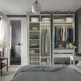Bedroom with modern wardrobe featuring shelves, hanging rods for clothes, and integrated lighting.